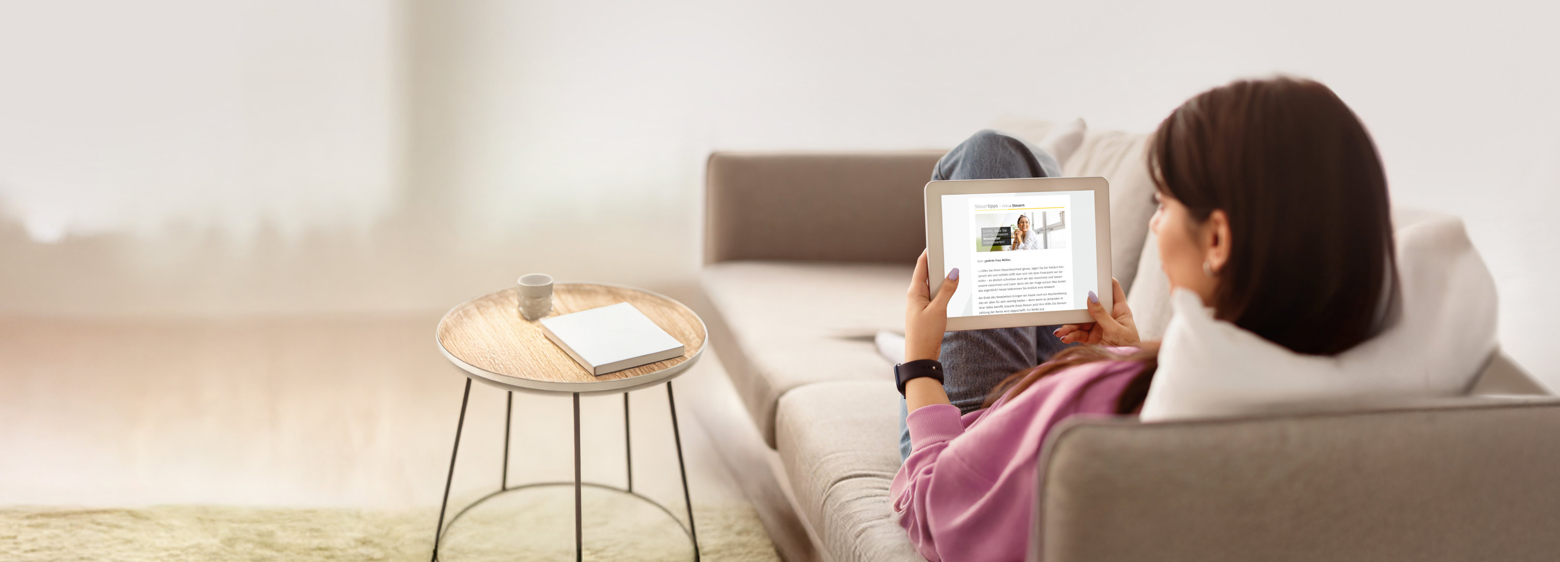 Frau liest ein Steuertipps Newsletter auf der Couch